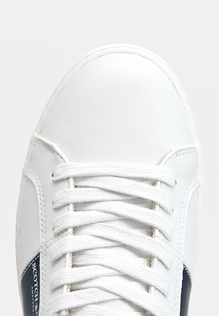 Weiße Leder-Sneaker mit glatter Textur, versehen mit weißen Schnürsenkeln, dunkelblauen Akzenten und einem seitlichen Logo-Patch. Abgerundete Zehenform.