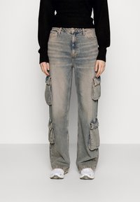 Jeans cargo de color azul claro con grandes bolsillos laterales y un corte relajado. Fabricados en denim con un ligero desvanecimiento y un diseño de pierna recta.
