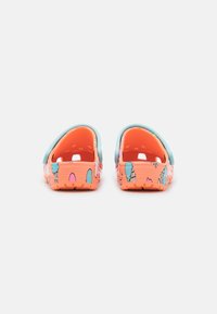 Zuecos coloridos con cuerpo principal en naranja y acentos en azul, decorados con patrones caprichosos de conos de helado y diseños juguetones.