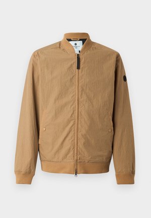 Hellbraune Bomberjacke mit Stehkragen, gerippten Bündchen, zwei seitlichen Taschen und einem schwarzen Logopatch auf dem linken Ärmel. Mit Reißverschluss.