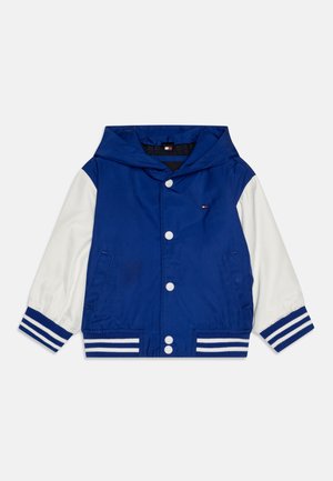 Blue and white hooded jacket with a button-up front, striped cuffs, and side pockets. Made from smooth, lightweight fabric.