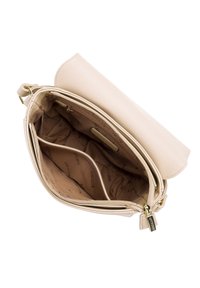 Beige läderhandväska med dragkedja, som har ett rymligt inre, mjuk textur och detaljer i guldfärgad metall. Flera fack inuti.