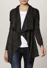 Svart och brun mönstrad cardigan med draperad front, långa ärmar och avslappnad passform. Har en texturerad tyg och asymmetrisk fåll.