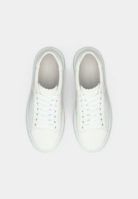 Άσπρα δερμάτινα αθλητικά παπούτσια με στρογγυλεμένες μύτες, επίπεδες κορδόνια και κυματιστές λεπτομέρειες κατά μήκος του γιακά. Λαστιχένιες σόλες και λεία επιφάνεια.