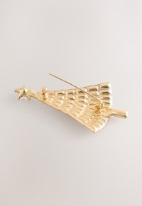 Gold-tone brooch shaped like a stylized flower with textured surface, featuring a star accent, and a pin back for attachment.