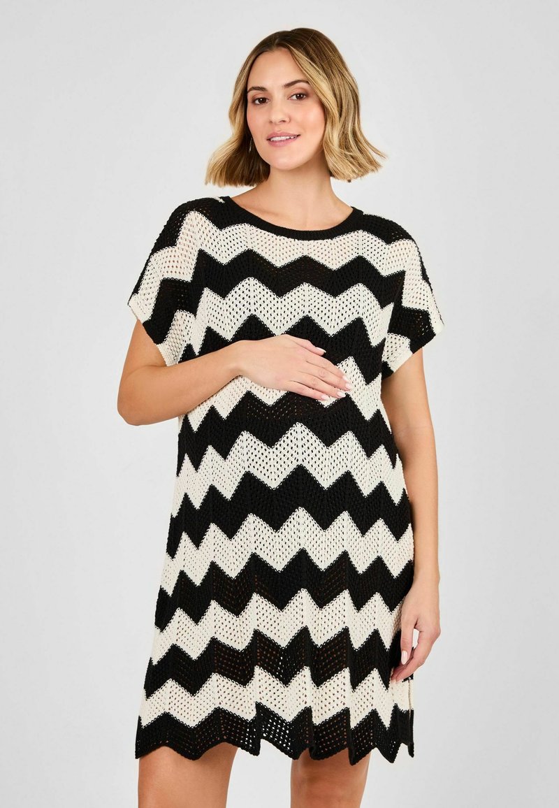 Abito in maglia con motivo a zig zag in bianco e nero, maniche corte, scollatura tonda e vestibilità ampia. Tessuto a rete aperta in tutta la sua lunghezza.