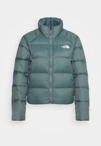 Giacca a vento in tessuto teal, con zip frontale, colletto alto, motivo trapuntato orizzontale e logo sul petto. Presenta due tasche laterali con zip.
