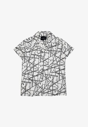 Camicia bianca a maniche corte con bottoni, decorata con un motivo a strisce di pellicola nere che si intersecano e piccoli quadrati neri, dotata di colletto e bottoni frontali.