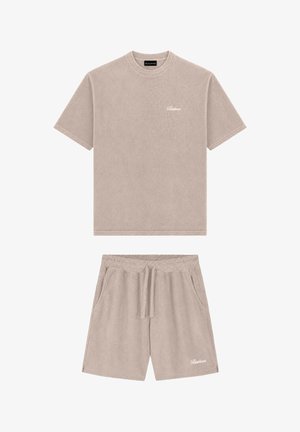 Beige top met korte mouwen en ronde hals en bijpassende short met elastische taille en aantrekkoord, beide met klein wit logo geborduurd.