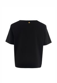 T-shirt nera a maniche corte con una vestibilità ampia. Presenta un'etichetta quadrata gialla nella parte posteriore del collo. Tessuto morbido e liscio.