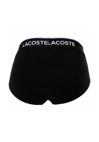 Zwarte katoenen onderbroek met een gladde textuur en een brede witte tailleband met "LACOSTE" in zwarte letters.