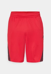Røde sports shorts med elastisk talje og sorte Adidas-striber på siderne mod en enkel hvid baggrund.