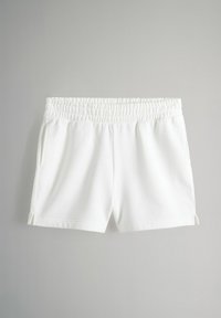 Vita bomullsshorts med elastisk midja, sidofickor och slitsar på fållen. Slät textur och avslappnad design.