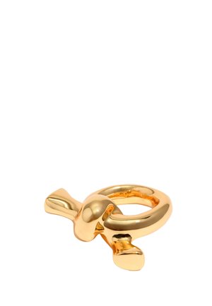 Gold metal ring with a smooth, rounded design and two elongated accents. Reflective surface, minimalistic shape.