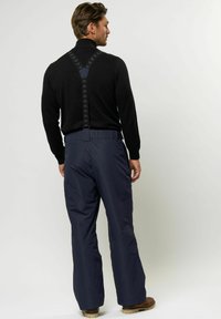 Mornarska snežna hlače z nastavljivimi črnimi naramnicami in oprijetim krojem. Narejene so iz vodoodpornega materiala z ojačanimi šivi.