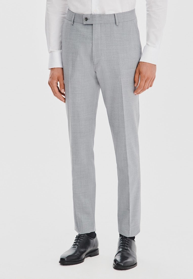 Jasnoszare spodnie wykonane z teksturowanej tkaniny, charakteryzujące się dopasowanym krojem, bocznymi kieszeniami i pojedynczym zapięciem na guzik. W połączeniu z czarnymi butami eleganckimi.