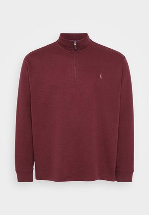 Bordeaux langharige pullover met een kwart-rits hals en geribbelde manchetten. Bevat een klein logo op de borst. Zacht, textuurmateriaal.