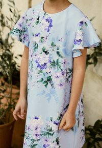 Hellblaues Kleid mit floralem Muster in Lila und Grün. Verfügt über ausgestellte Ärmel und strukturierten Stoff. Mittellanges Design.