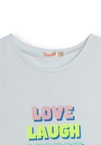 Biała bawełniana koszulka z wielokolorowym, błyszczącym napisem "KOCHAJ, ŚMIEJ SIĘ, ŚNIJ" w kolorach różowym, niebieskim, zielonym i żółtym. Okrągły dekolt.