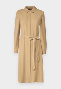 Beżowa sukienka koszulowa z długim rękawem, z kołnierzykiem, z przodu zapinana na guziki, z dopasowanym paskiem z tego samego materiału zawiązanym w talii. Gładka tekstura, minimalistyczny design.