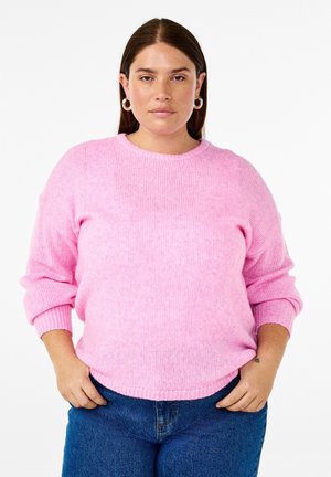 Helles rosa Strickpullover mit Rundhalsausschnitt, gerippter Textur und lockerer Passform. Verfügt über lange Ärmel und einen leicht abgerundeten Saum. Kombiniert mit blauen Jeans.