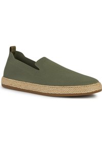 Zapatos verdes sin cordones, hechos de un tejido texturizado, con una suela media de yute trenzado y una suela exterior de goma. Sin cierres visibles ni cordones.