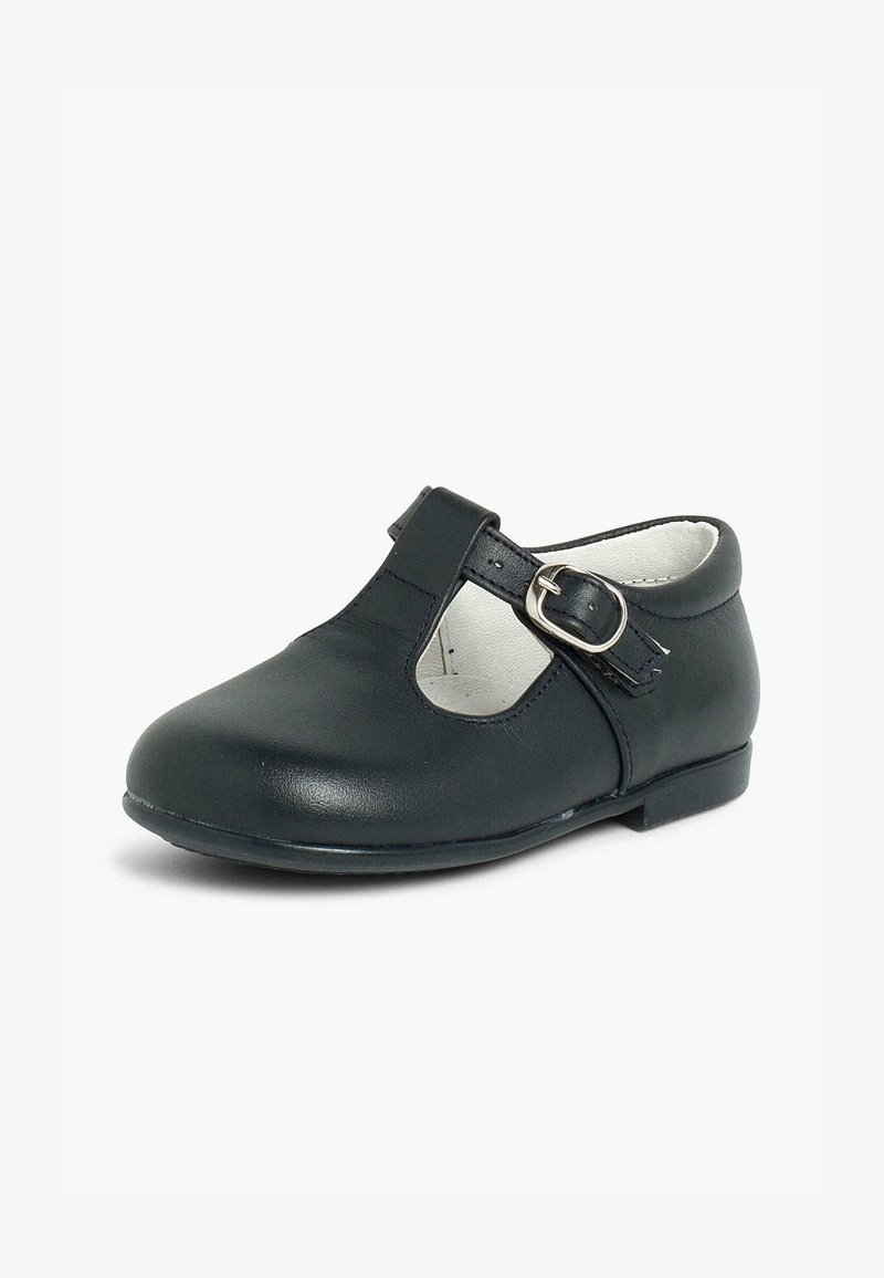 Chaussures Mary Jane en cuir noir avec un bout rond, des découpes sur les côtés et une sangle à boucle réglable. Texture lisse et petit talon.