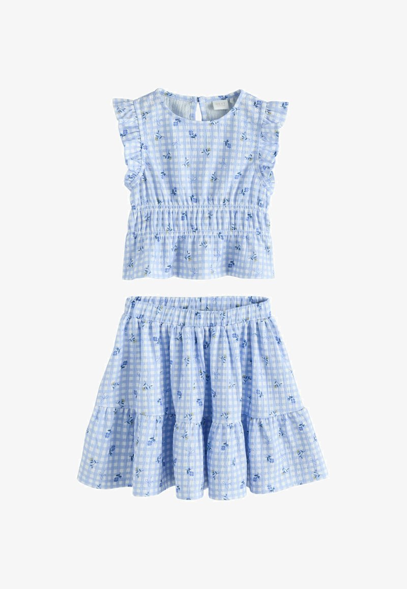 Top sin mangas de cuadros vichy azul claro con volantes en las mangas y falda a capas a juego, ambas con pequeños estampados florales azules.