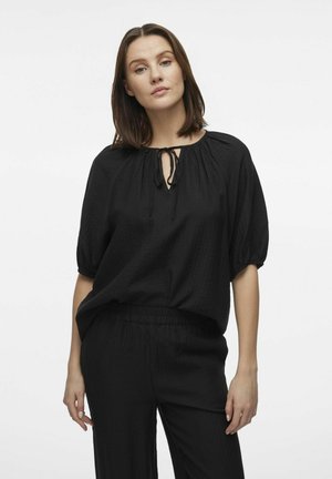 Black, textured, loose-fitting blouse with a round neckline and keyhole detail, featuring short puff sleeves and a drawstring tie at the neck.