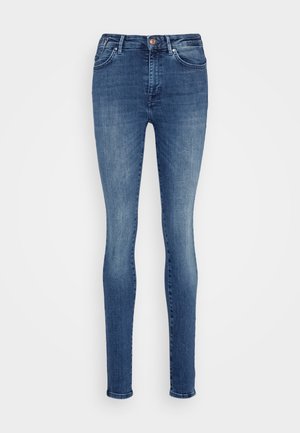 Tievās džinsās no vidējas svara denima, ar vidēju jostas līmeni, tumši zila krāsa, piecas kabatas un viena pogas aizdare.