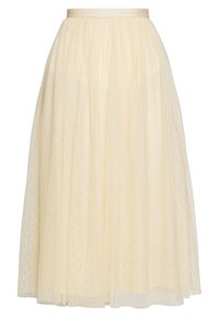 Jupe midi fluide en tulle jaune clair avec une texture transparente, dotée d'une taille en ruban doux et de subtils motifs d'étoiles brodés.