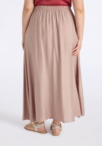 Gonna lunga con vita elastica, realizzata in un tessuto morbido e leggero di colore rosa pallido, con una silhouette fluida e senza motivi visibili.