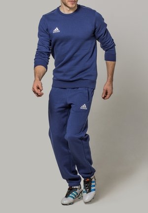 Felpa sportiva blu e pantaloni abbinati, realizzati in tessuto morbido, con il logo Adidas bianco sul petto e sulla coscia.