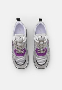 Sneaker grigie con materiali in mesh e scamosciato, con accenti viola, hardware riflettente argento e lacci testurizzati.