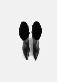 Black leather ankle boots with a pointed toe, smooth texture, and a side zipper. Designed with a sleek, form-fitting silhouette.