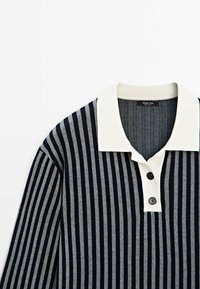 Navy and gray striped polo shirt with a white collar, featuring two black buttons at the placket. Soft knit fabric, modern design.