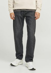 Donkere spijkerbroek met een ontspannen pasvorm, voorzien van een klassiek rechte pijpontwerp. De stof heeft een subtiele textuur en een lichte vervaging.