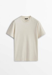 Effen beige T-shirt met korte mouwen en ronde hals, plat gelegd op een witte achtergrond, voorzijde en minimalistisch ontwerp zichtbaar.