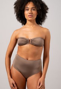 Braunes Bikini-Set mit einem trägerlosen Oberteil mit Raffung und einem zentralen Hardware-Detail, kombiniert mit hochgeschnittenen Unterteilen in passender Farbe.