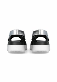 Black and silver sandals with an open back, wide metallic straps, and a thick, white platform sole featuring a textured tread design.