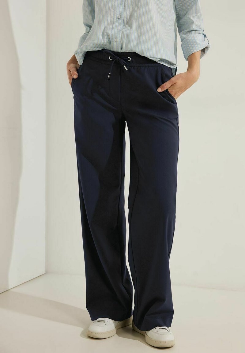 Marina vida byxorna med vida ben av lättviktig tyg, med elastisk midja och snörning samt sidofickor. Matchas med vita sneakers.