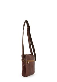 Brun læder crossbody taske med en glat overflade, lynlåsfrontlomme, justerbar strop og guldfarvede hardware-detaljer.