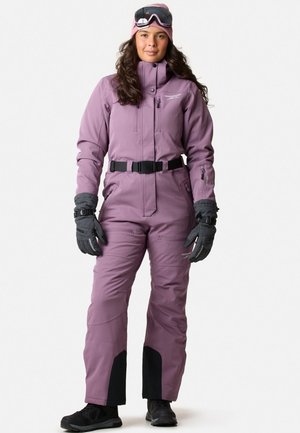 Ski suit in soft purple fabric with a high collar, adjustable waist, and multiple pockets. Paired with gray gloves and black boots.