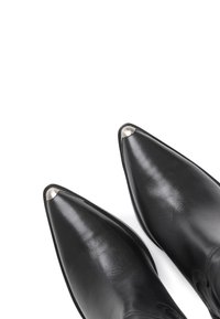 Bottines en cuir noir avec des pointes en amande, ornées de bouts en argent brillant. Texture lisse et design minimaliste avec des semelles noires.