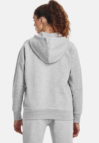 Grey hooded sweatshirt with a relaxed fit, ribbed cuffs, and hem. Soft, textured fabric, featuring a spacious hood at the back.