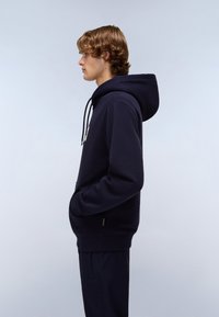 Felpa blu navy realizzata in morbido tessuto, con tasca a marsupio, cappuccio regolabile con cordini e un sottile dettaglio del logo sul davanti.