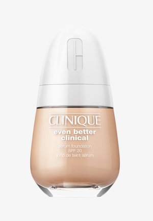 Clinique serum foundation in een gebogen, transparante glazen fles met een witte dop. Het etiket toont de productnaam, SPF 20 en ingrediëntdetails.
