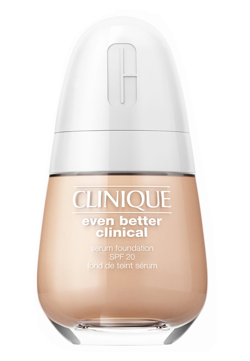 Clinique Serum Foundation in einer geschwungenen, transparenten Glasflasche mit einem weißen Deckel. Das Etikett zeigt den Produktnamen, SPF 20 und Zutateninformationen.