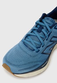 Lyseblå sportsko med mesh-overdel og kontrasterende mørkeblå snørebånd, med 'FRESH FOAM' mærkning på sålen og struktureret overflade.