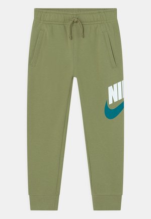 Jogging vert clair avec taille élastique, cordon de serrage, poches latérales et grand logo Nike blanc avec swoosh bleu sur le haut de la jambe gauche.